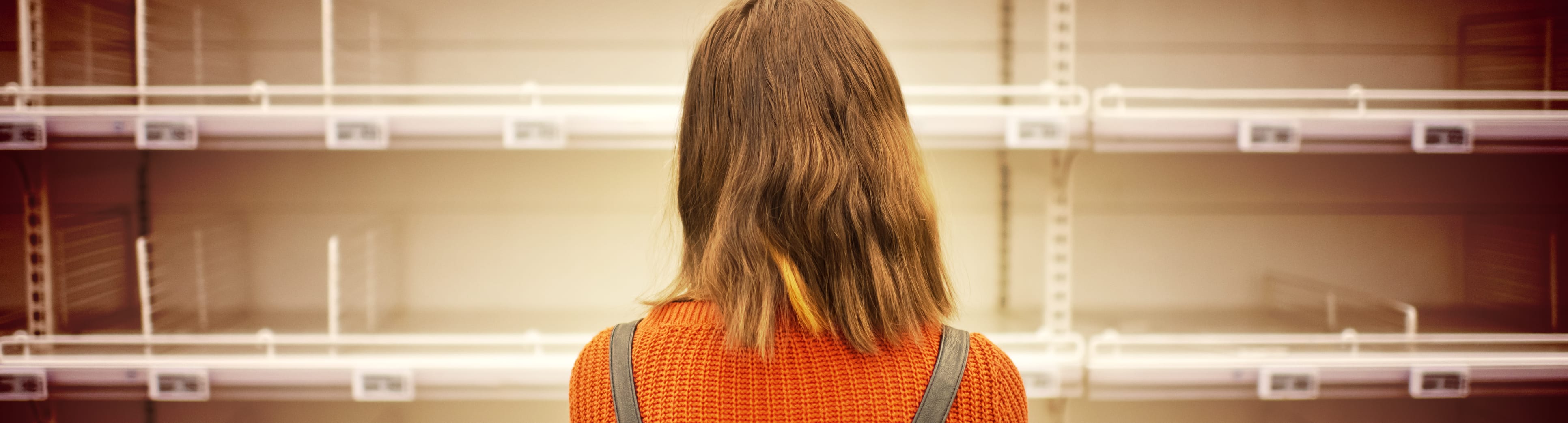 woman looking at empty shelves