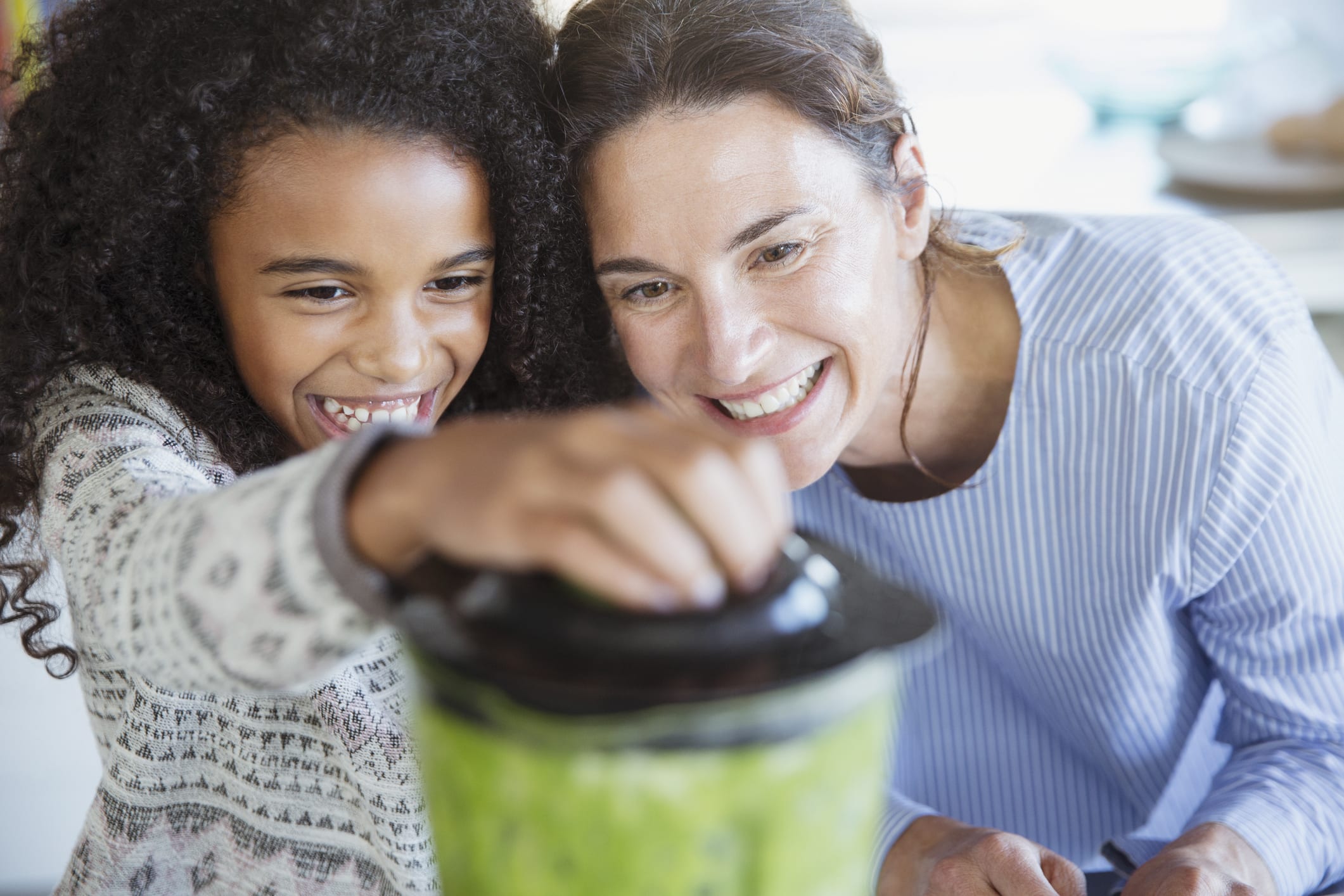 mom and daughter make smoothie