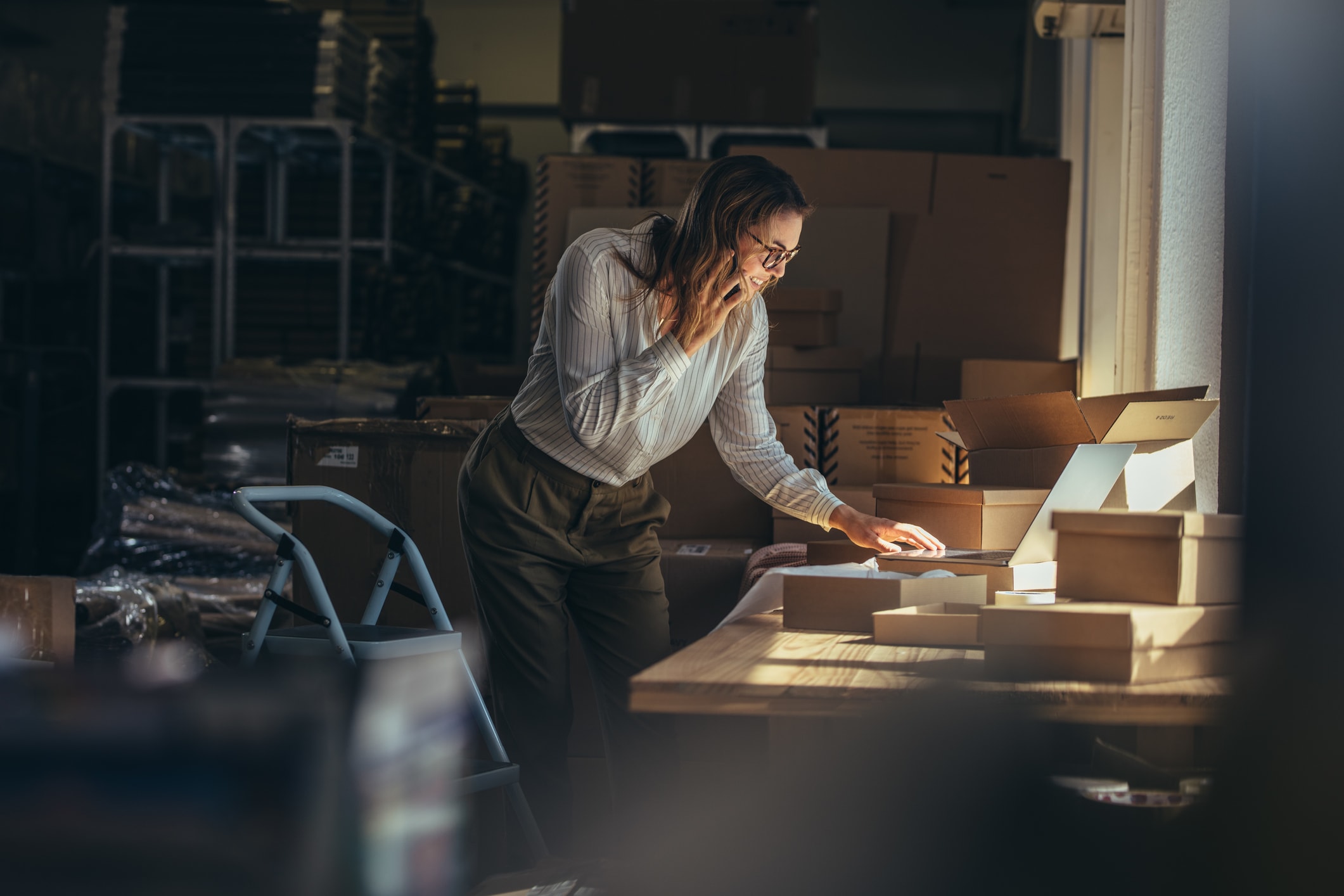 Businesswoman Working on a Laptop and Talking on the Phone