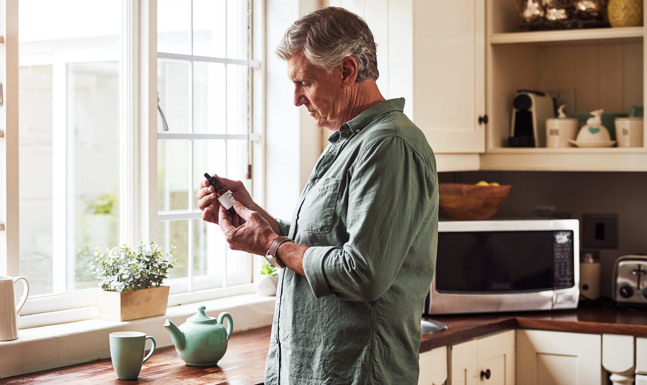 Man Preparing a Cup of Tea with CBD Oil