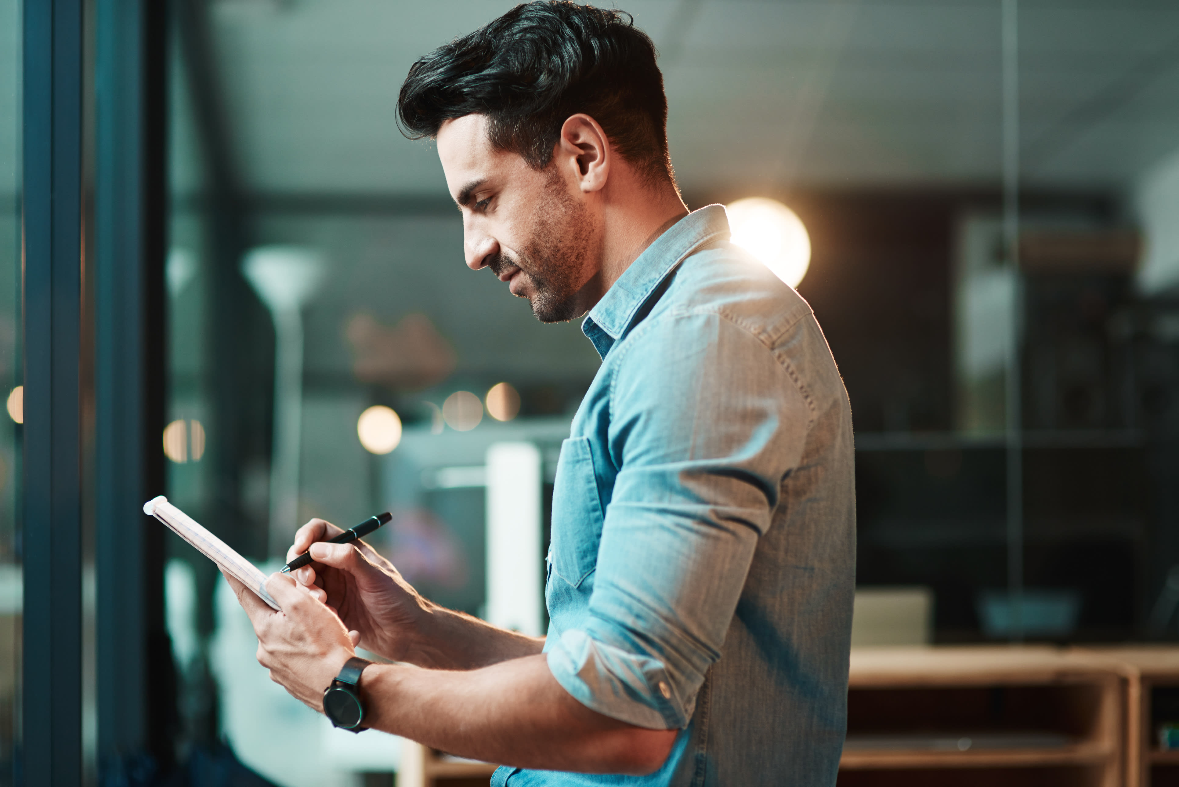 man writing on notepad