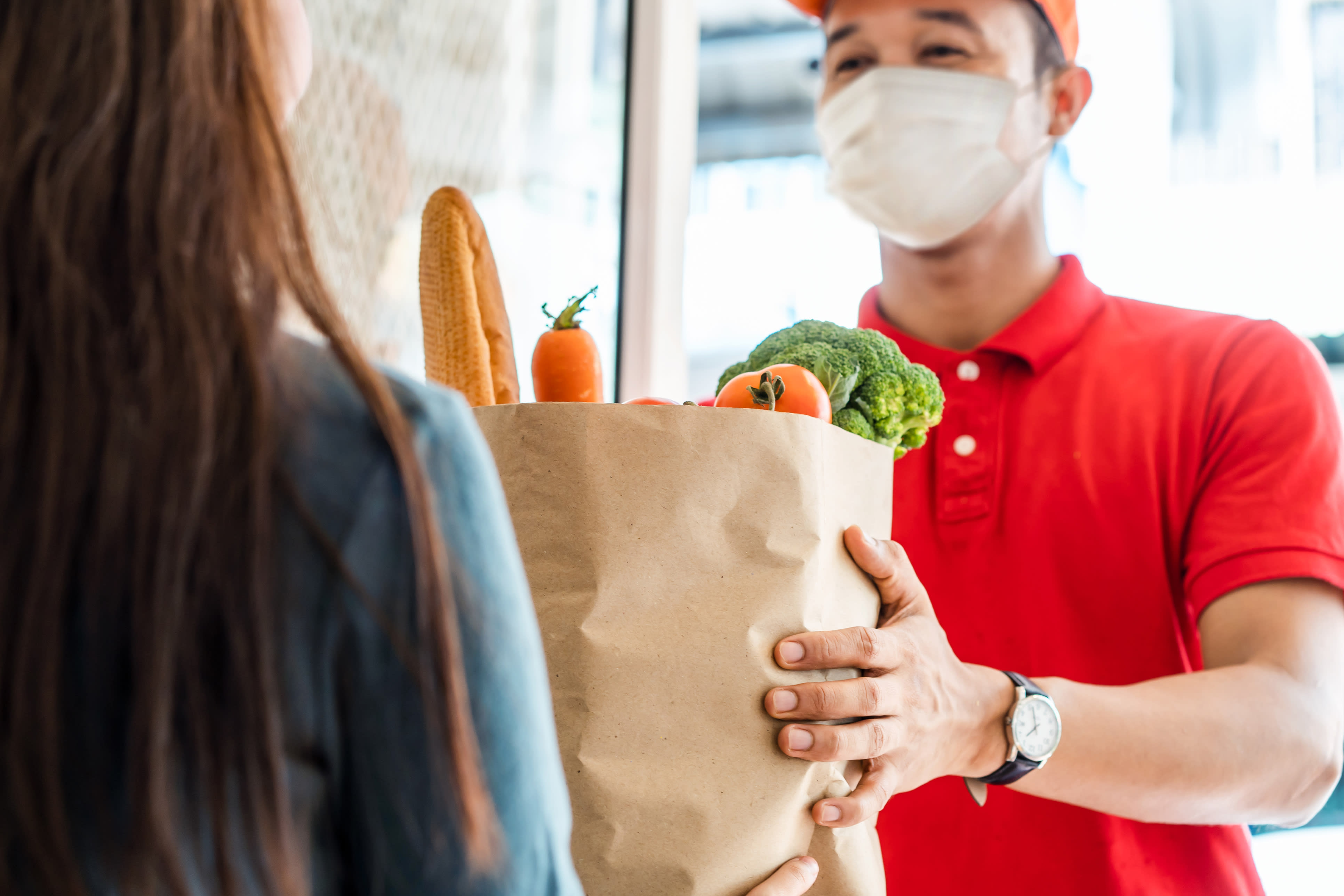 person in mask delivering groceries