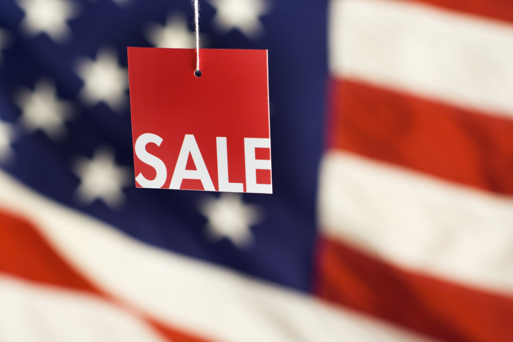 sale sign in front of flag