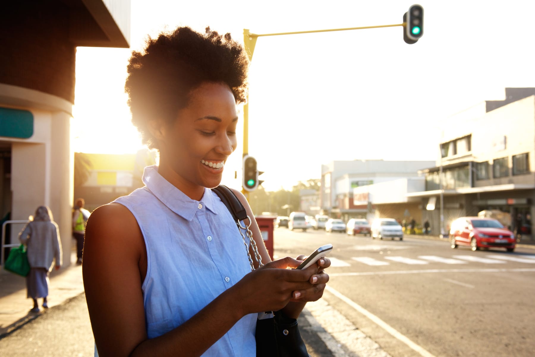 Black woman uses phone on street