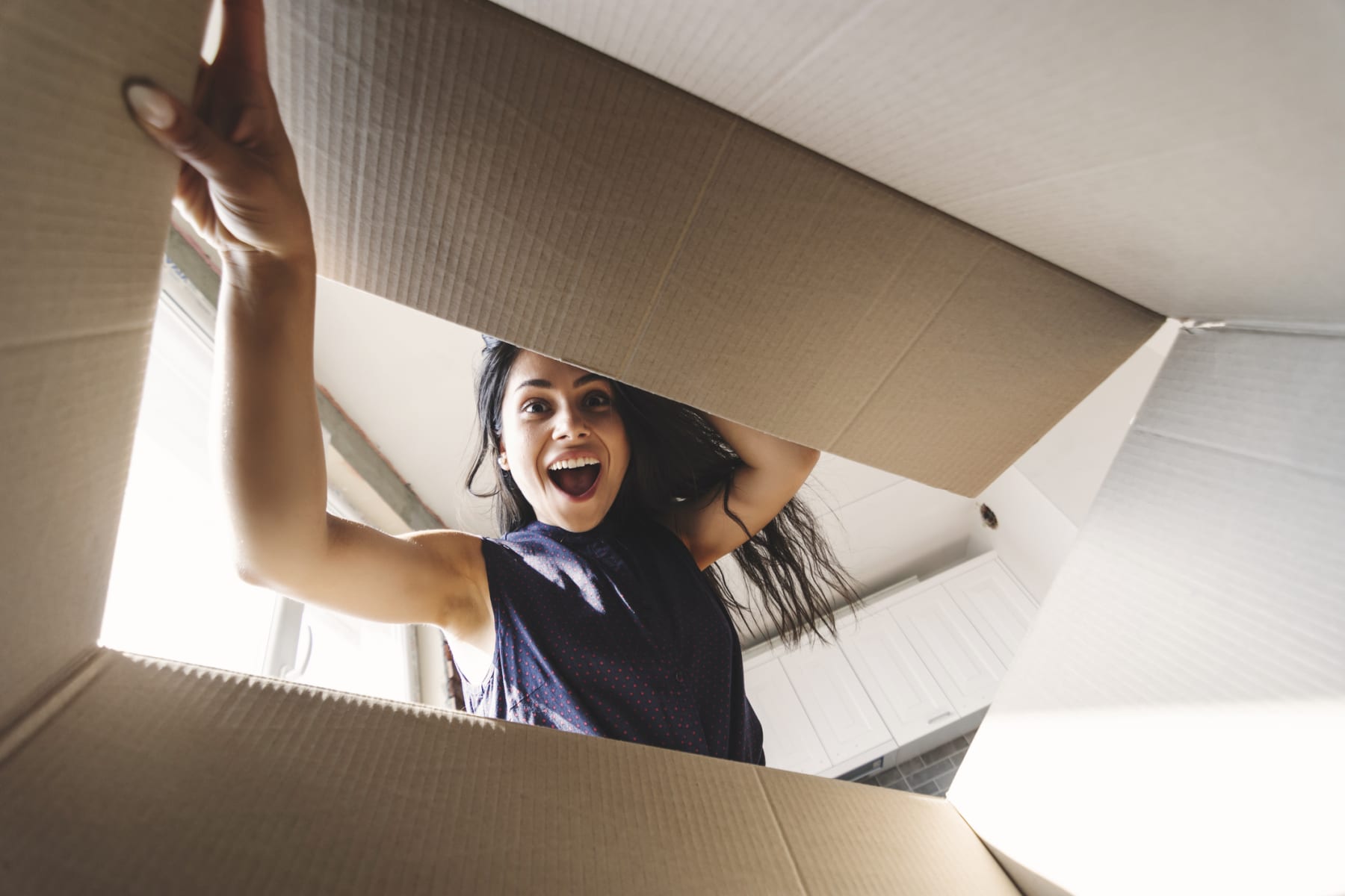 Smiling woman opening a cardboard box